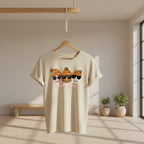A person wearing a  orange crewneck sweatshirt with a graphic of three cartoon faces in orange beanies and sunglasses above the words 'SQUAD GOALS'. 